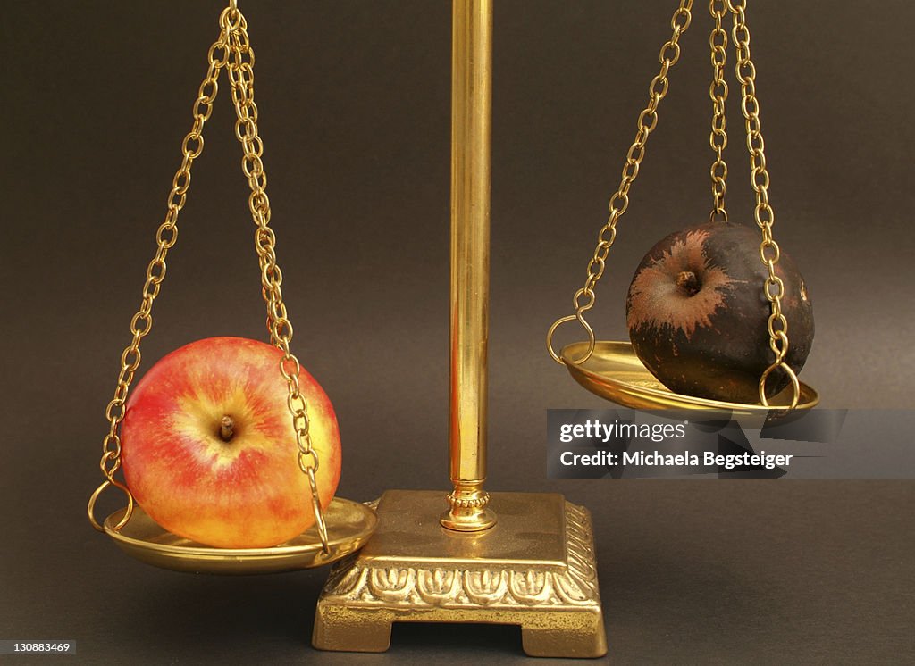Red and rotten apple on a scale