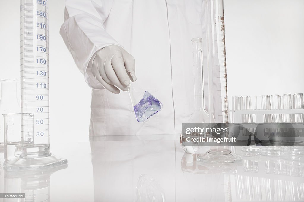 Chemist checking liquid in flask in a lab