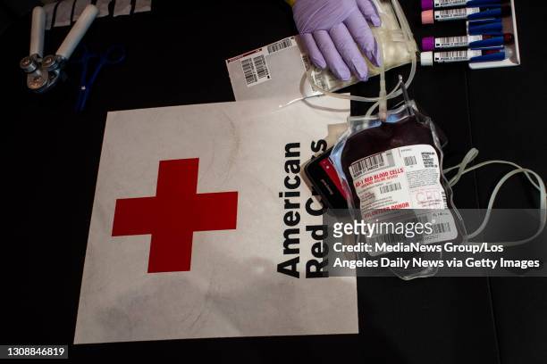 Phlebotomist Adel Velasco prepares a blood donation at a Red Cross blood drive with L.A. Care Health Plan in Los Angeles on Tuesday, March 23, 2021....