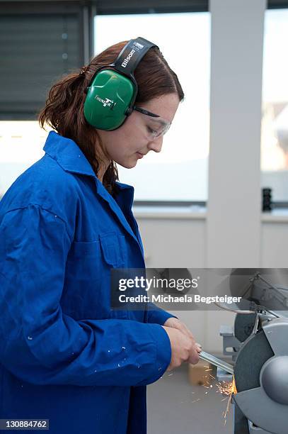 young woman working at a grinding machine - 25 male tradesman stock pictures, royalty-free photos & images