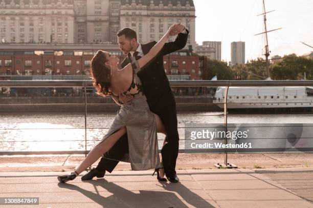 male and female tango dancers practicing on pier during summer - puerto madero stock-fotos und bilder