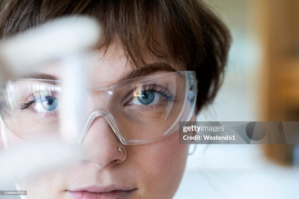 Close-up of female technician wearing eyeglasses working while standing in laboratory