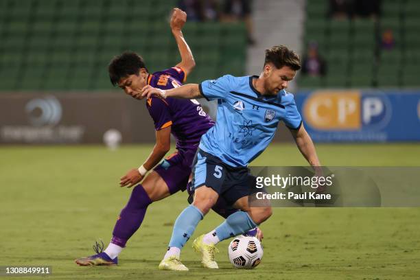 Kosuke Ota of the Glory and Alex Baumjohann of Sydney contest for the ball during the round 13 A-League match between Perth Glory and Sydney FC at...