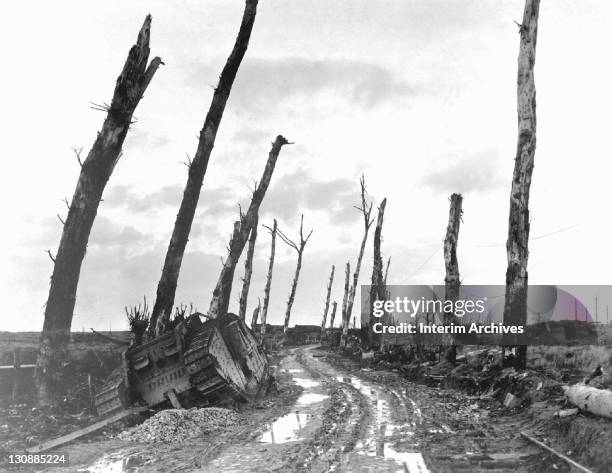 Destroyed tank lies abandoned at the side of a muddy road, on a devastated street corner in the city of Poelcapelle, Belgium, December 1918. US Army...