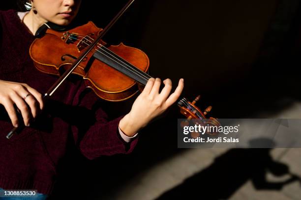 woman playing violin on the street - violine stock-fotos und bilder