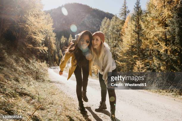 playful friends laughing while standing together in forest - backpacking fun stock pictures, royalty-free photos & images