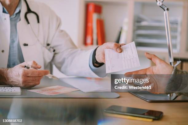 doctor giving prescription to patient at doctor's office - prescription imagens e fotografias de stock