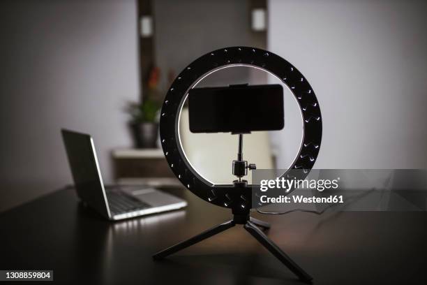 smart phone with led ring light and laptop on table - fotografische ausrüstung stock-fotos und bilder