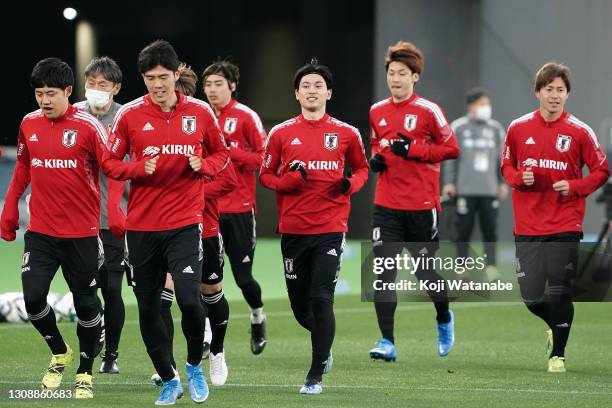 Japanese players warm up during a training session ahead of the international friendly match between Japan and South Korea at the Nissan Stadium on...