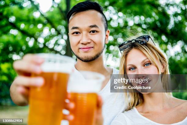 multiethnic group of young people drinking beer - biergarten stock-fotos und bilder