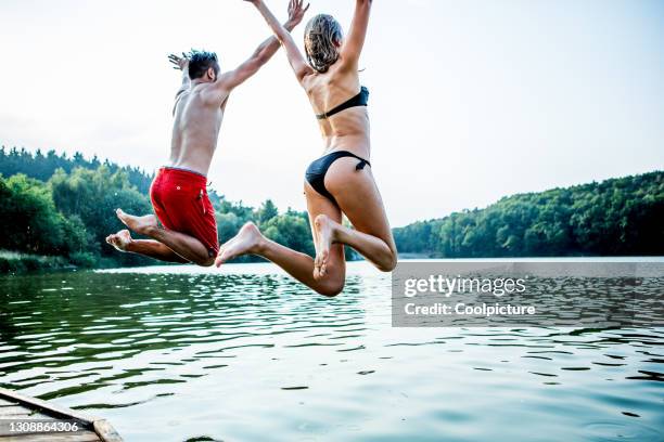 young couple enjoying swimming. - jetty stock pictures, royalty-free photos & images