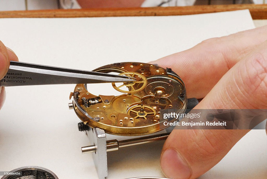 Watchmaker cleaning a pocket watch