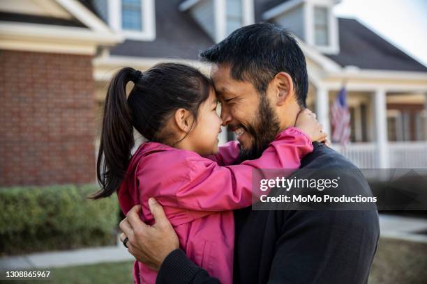 father and daughter in front of suburban home - chaqueta de ante fotografías e imágenes de stock