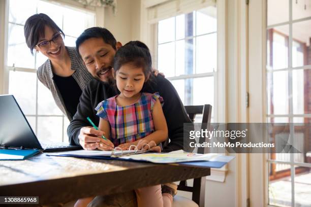 father working from home and helping daughter with schoolwork - chinese tutor study stock pictures, royalty-free photos & images
