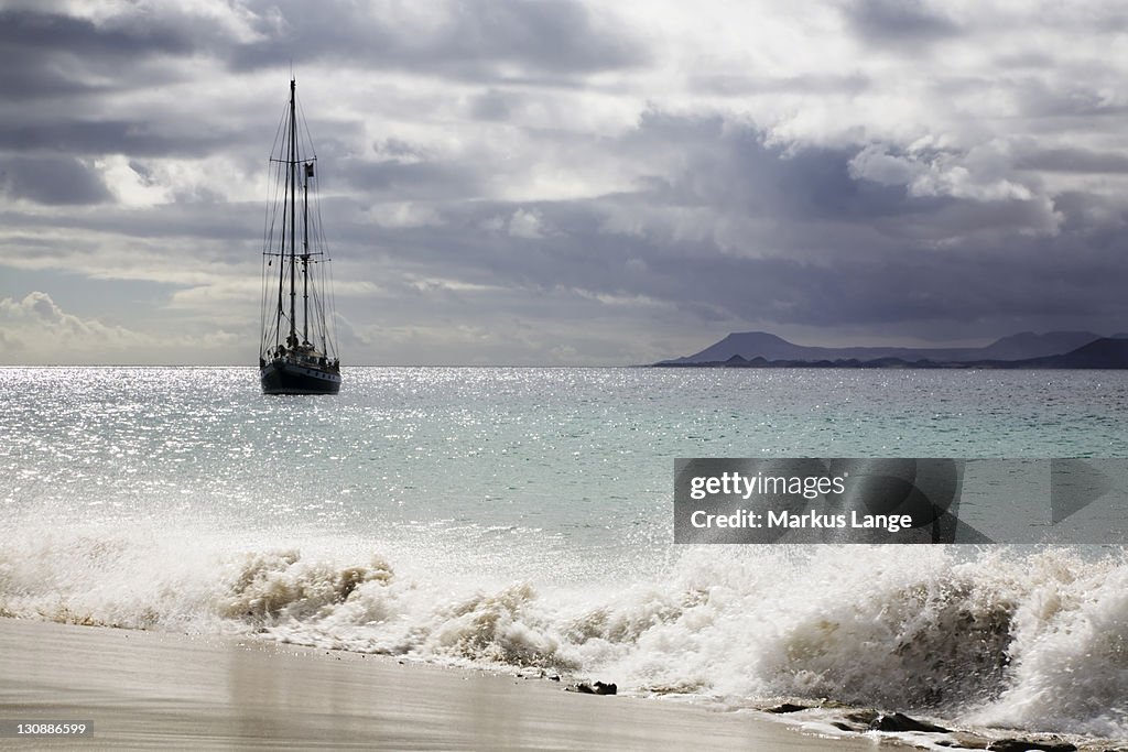 Sailing boat on the Playa de Mujeres beach near Playa Blanca, Fuerteventura in the back, Lanzarote, Canary Islands, Spain, Europe