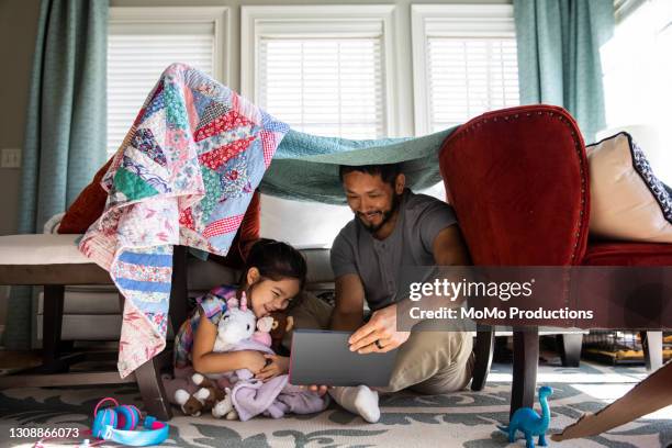 father and daughter playing in homemade fort - chinese family taking photo at home stock-fotos und bilder