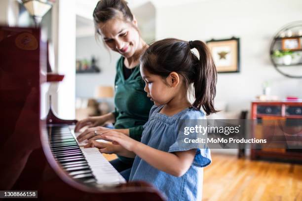 mother and daughter playing piano - pianist stock pictures, royalty-free photos & images