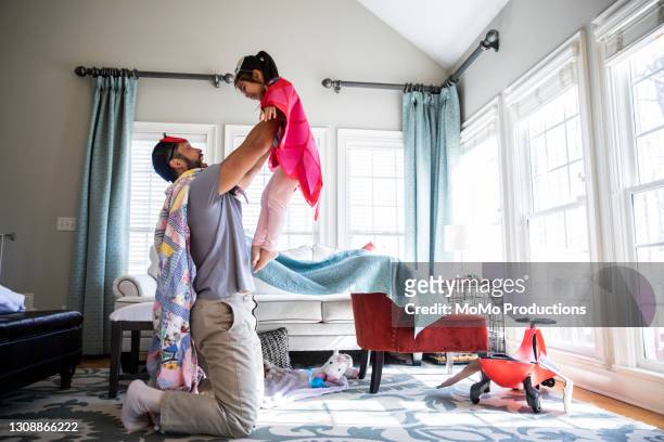 father and daughter playing in homemade costumes - superhero kid stockfoto's en -beelden