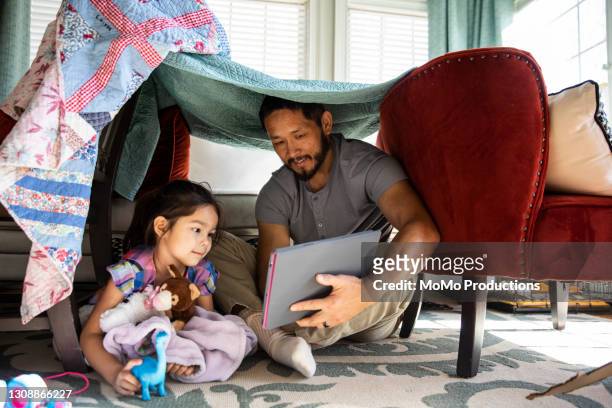 father and daughter playing in homemade fort - stories of the day stock-fotos und bilder