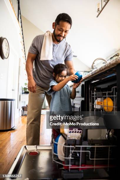 father showing young daughter how to load dishwasher - pai dono de casa - fotografias e filmes do acervo