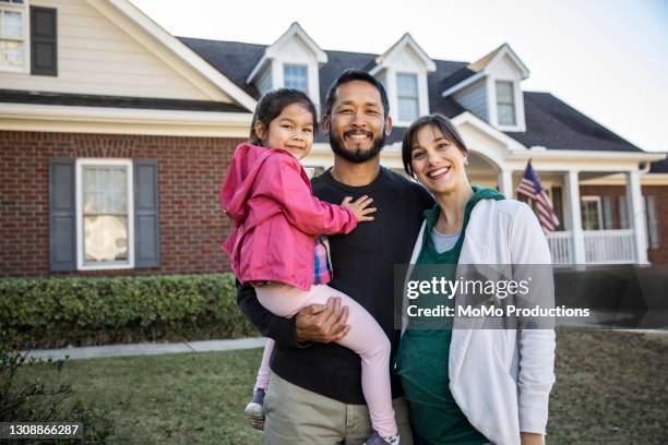 portrait of family in front of suburban home - dreiviertel vorderansicht stock-fotos und bilder