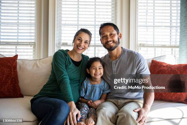 portrait of family at home on sofa - mixed race person stockfoto's en -beelden