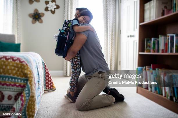 father embracing young daughter before school - beginn des schuljahres stock-fotos und bilder