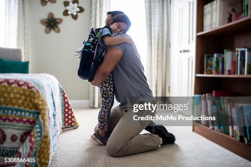 Father embracing young daughter before school Father embracing young daughter before school