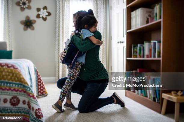 mother embracing young daughter before school - mom and young daughter ストックフォトと画像