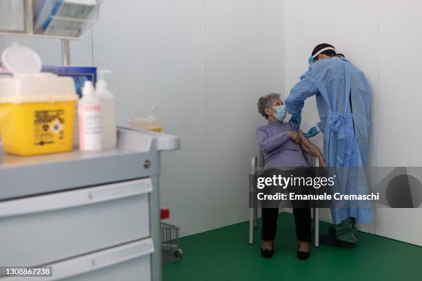 Nurse administers a dose of the Pfizer Biontech vaccine to an elderly woman at a sports center transformed into a vaccination hub on March 24, 2021...