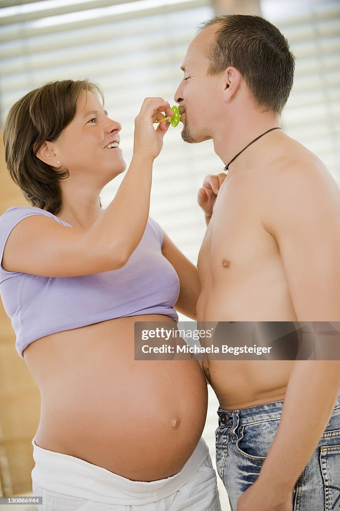 Expectant parents with a pacifier