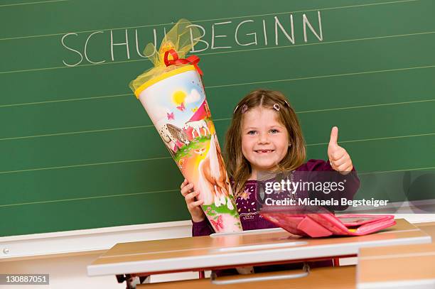 firstgrader holding her school cone on the first day of school - 6th grade girls stock pictures, royalty-free photos & images