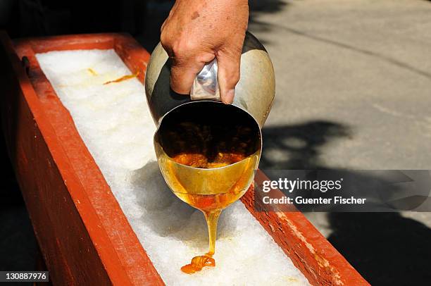 boiling maple syrup being poured onto snow to make maple syrup sweets, called maple taffy, sugar shack, ile d'orlã©an, canada, north america - molasses stock pictures, royalty-free photos & images