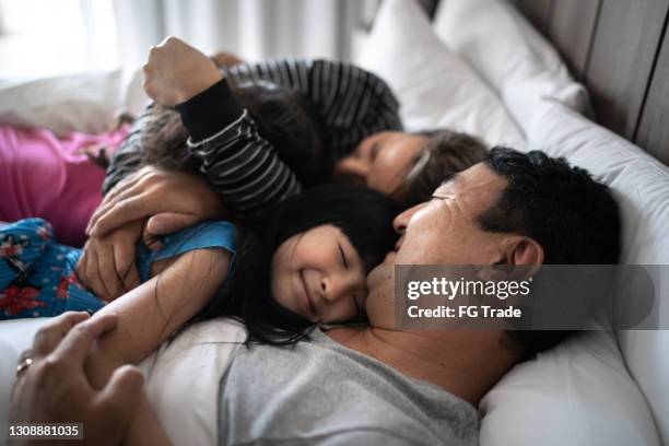 daughters embracing parents in bed in the morning - good night imagens e fotografias de stock