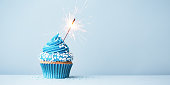 Blue celebration cupcake with sparkler and sprinkles
