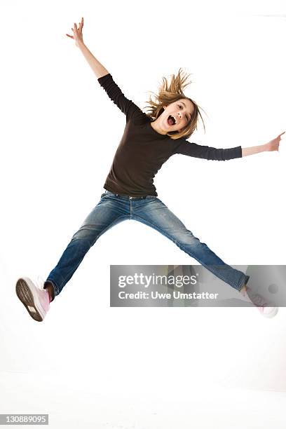 a girl leaping into the air - jumping casual clothing studio shot stock-fotos und bilder