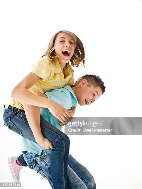 a boy carrying a girl piggyback - 12 13 jahre mädchen po stock-fotos und bilder