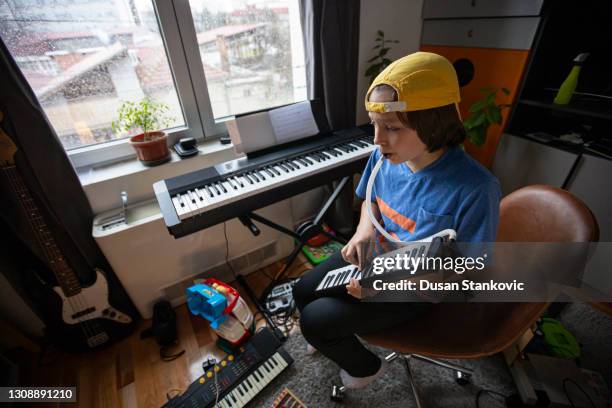 young boy with hat playing instruments - sintetizador imagens e fotografias de stock