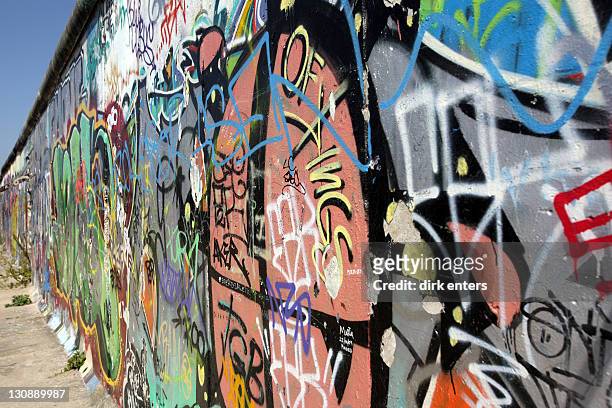berlin wall covered with graffiti at the eastside gallery, berlin, germany, europe - berlin graffiti stock-fotos und bilder