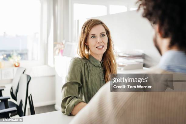 office manager discussing work with colleague - business people group brown stock pictures, royalty-free photos & images