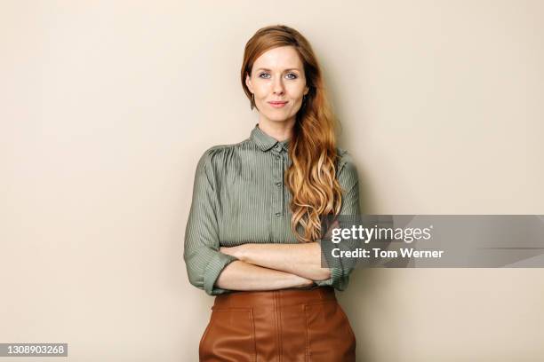 businesswoman smiling with arms folded - fond studio photo photos et images de collection