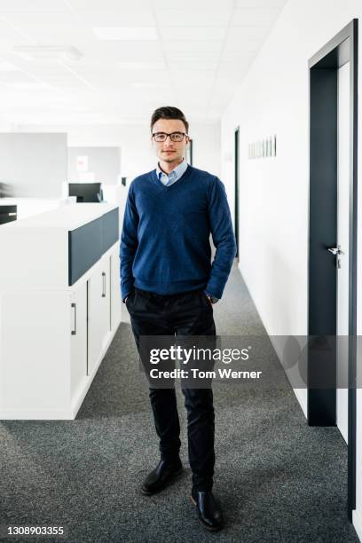 portrait of businessman standing in office - blue trousers stock-fotos und bilder