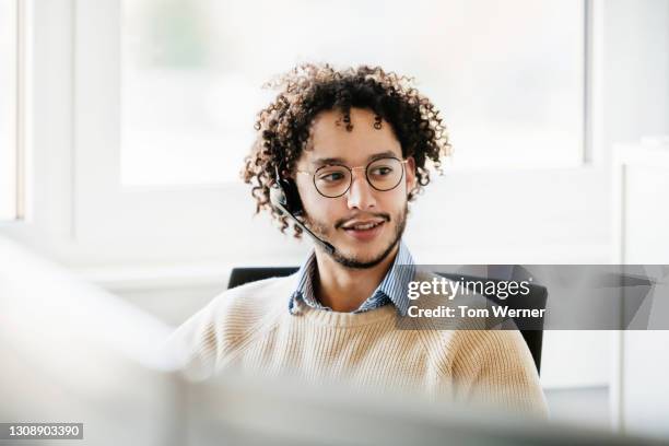 male office employee wearing wireless headset working at computer - call for help fotografías e imágenes de stock