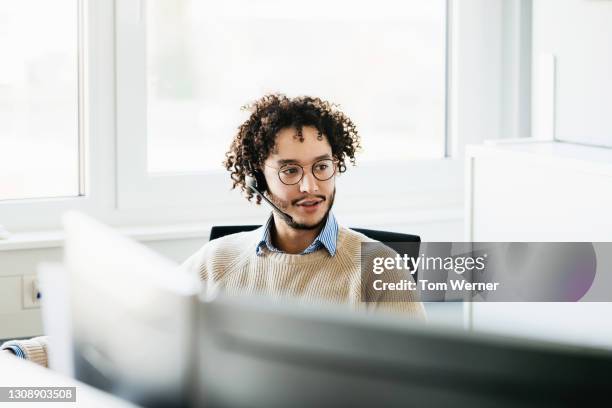 office employee working while talking to colleague - réceptionniste photos et images de collection