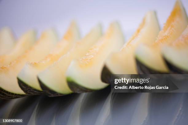 defocused row of a some slices of santa claus melon - melão imagens e fotografias de stock