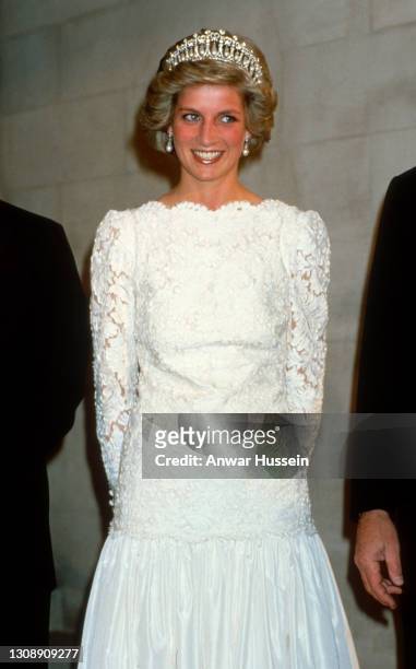 Diana, Princess of Wales, wearing a cream lace gown with a scalloped neckline designed by Murray Arbeid and the Cambridge Lover's Knot diamond and...