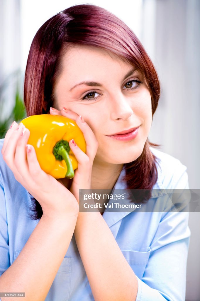 Young woman with yellow bell pepper
