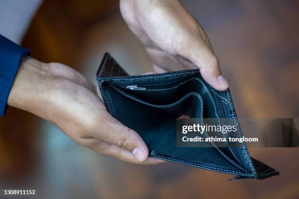 man holding and showing an empty wallet (no money) - handtasche offen stock-fotos und bilder