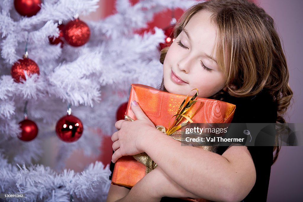 Girl hugging a Christmas present