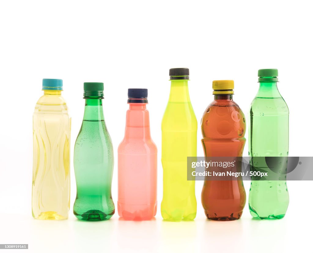 Close-up of multi colored plastic bottles against white background